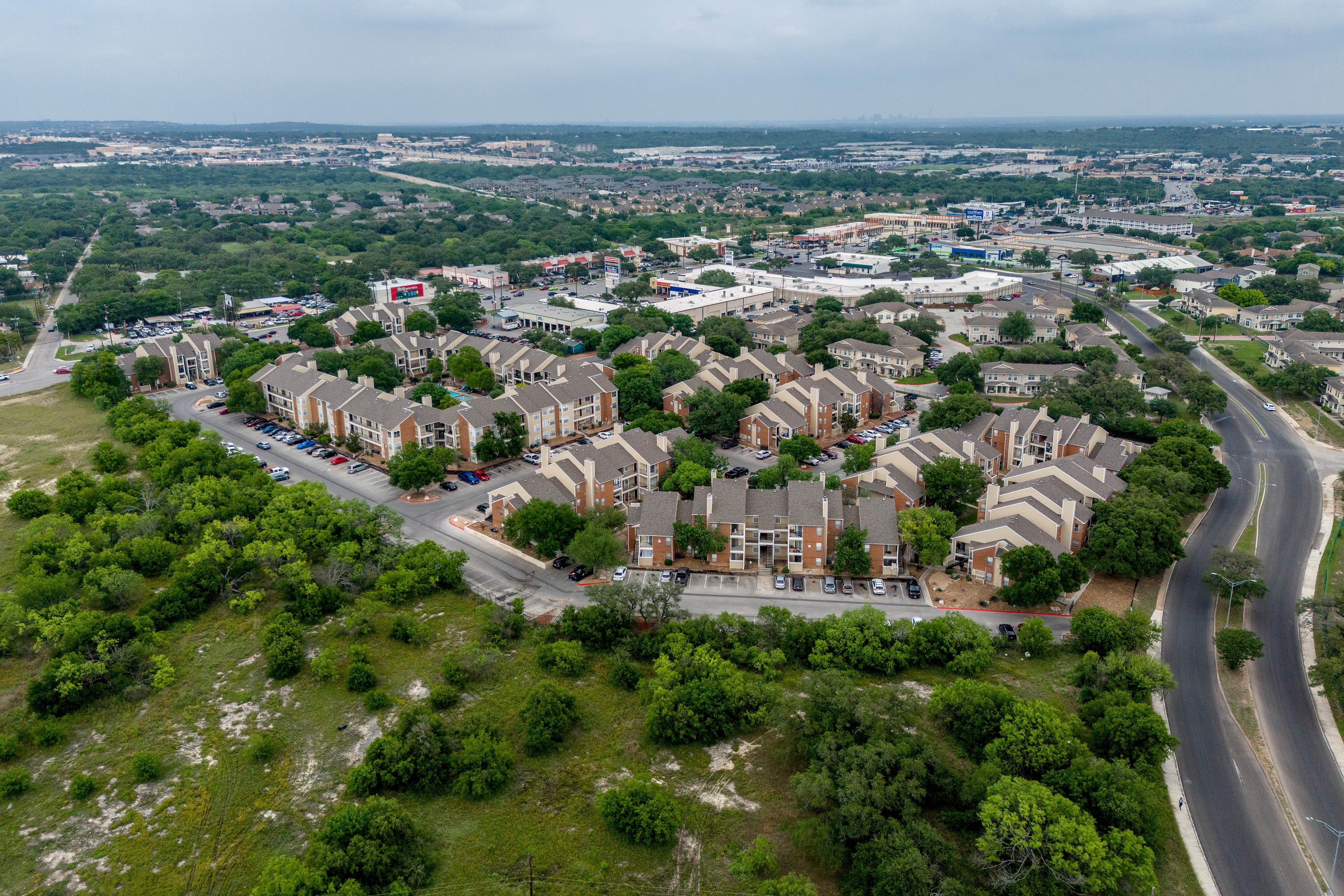 A bird's eye view of a residential area with a road running through it.